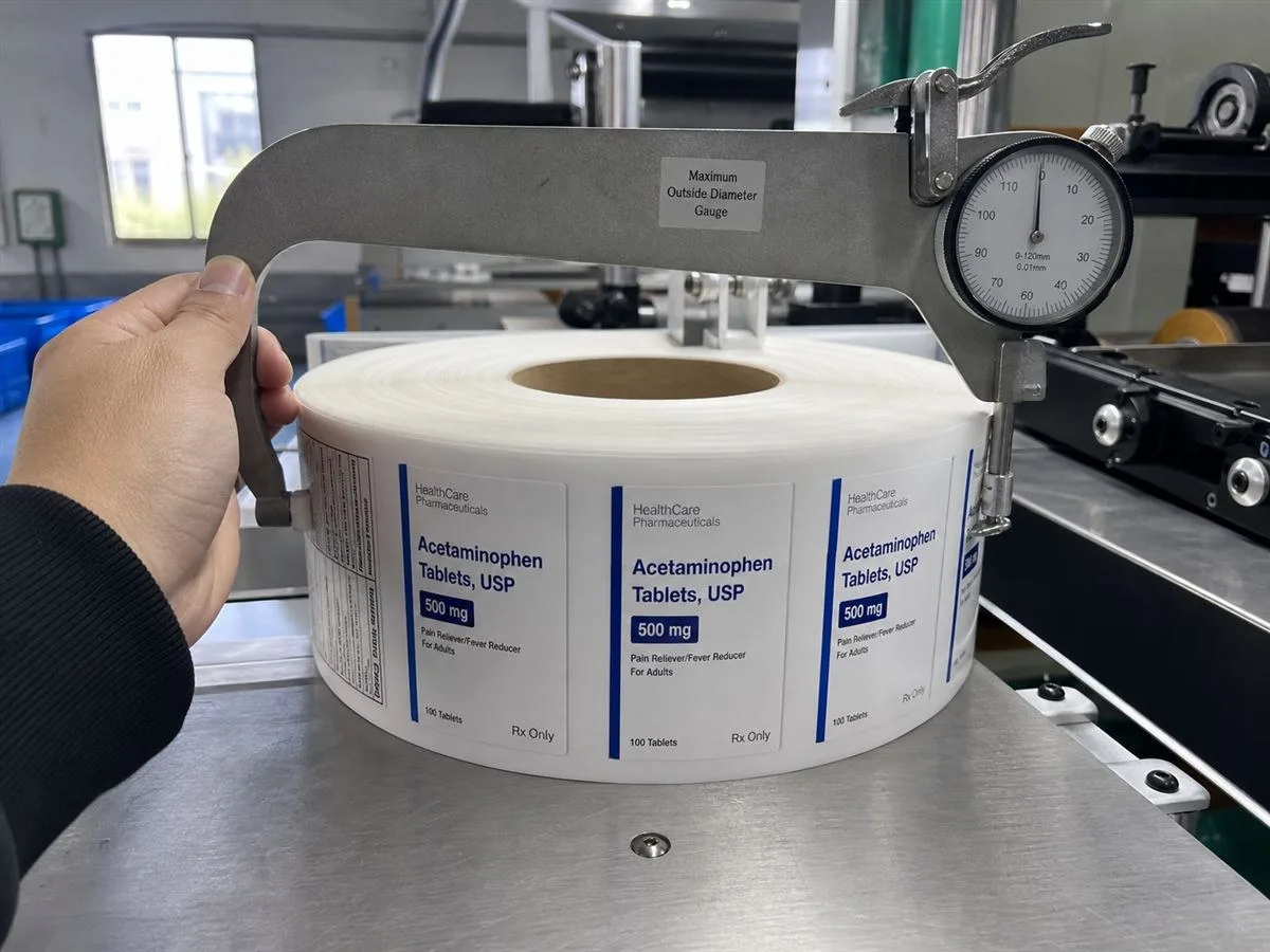 Finished label roll diameter measured against a dispenser max OD gauge