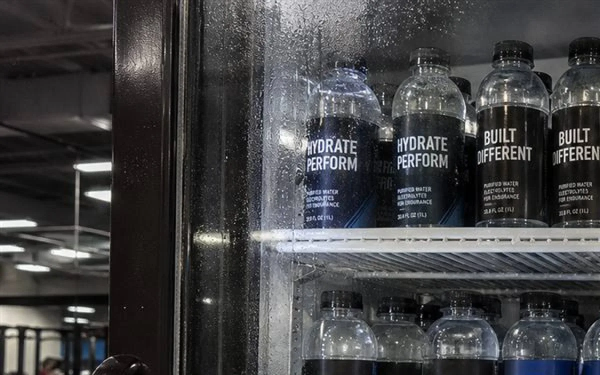 Gym cooler door with rows of sports water bottles