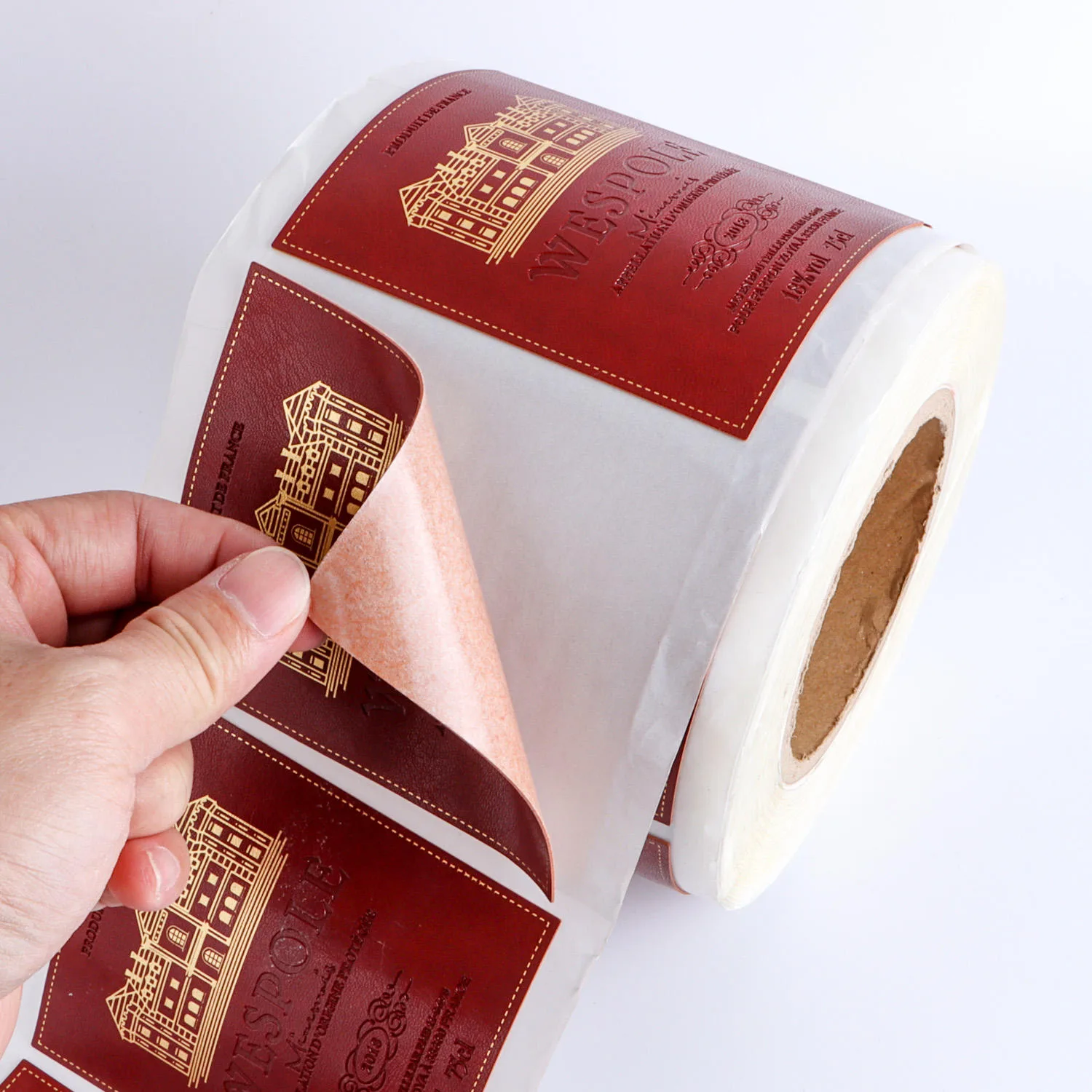 Red Wine Label Being Peeled From Roll