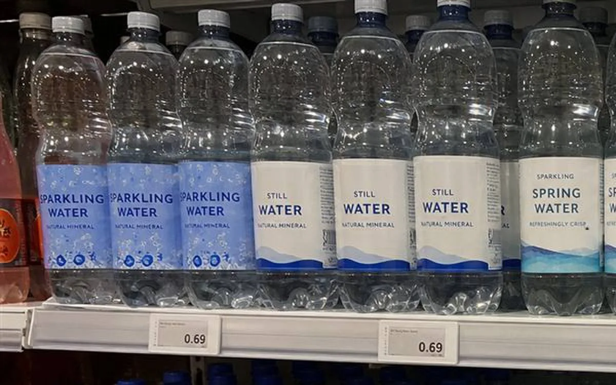 Retail shelf of bottled water under store lighting