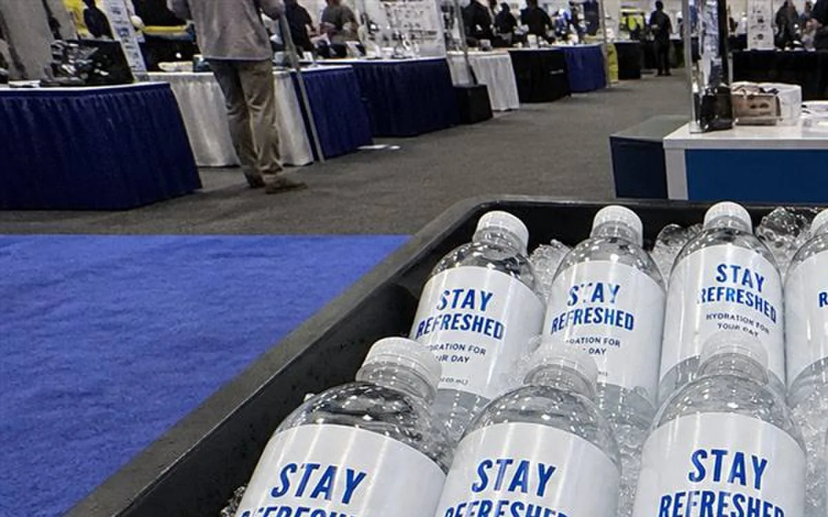 Trade-show booth water bottles packed in ice tray with branded labels